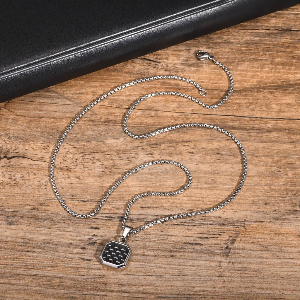 Silver chain necklace with a pendant on a wooden surface