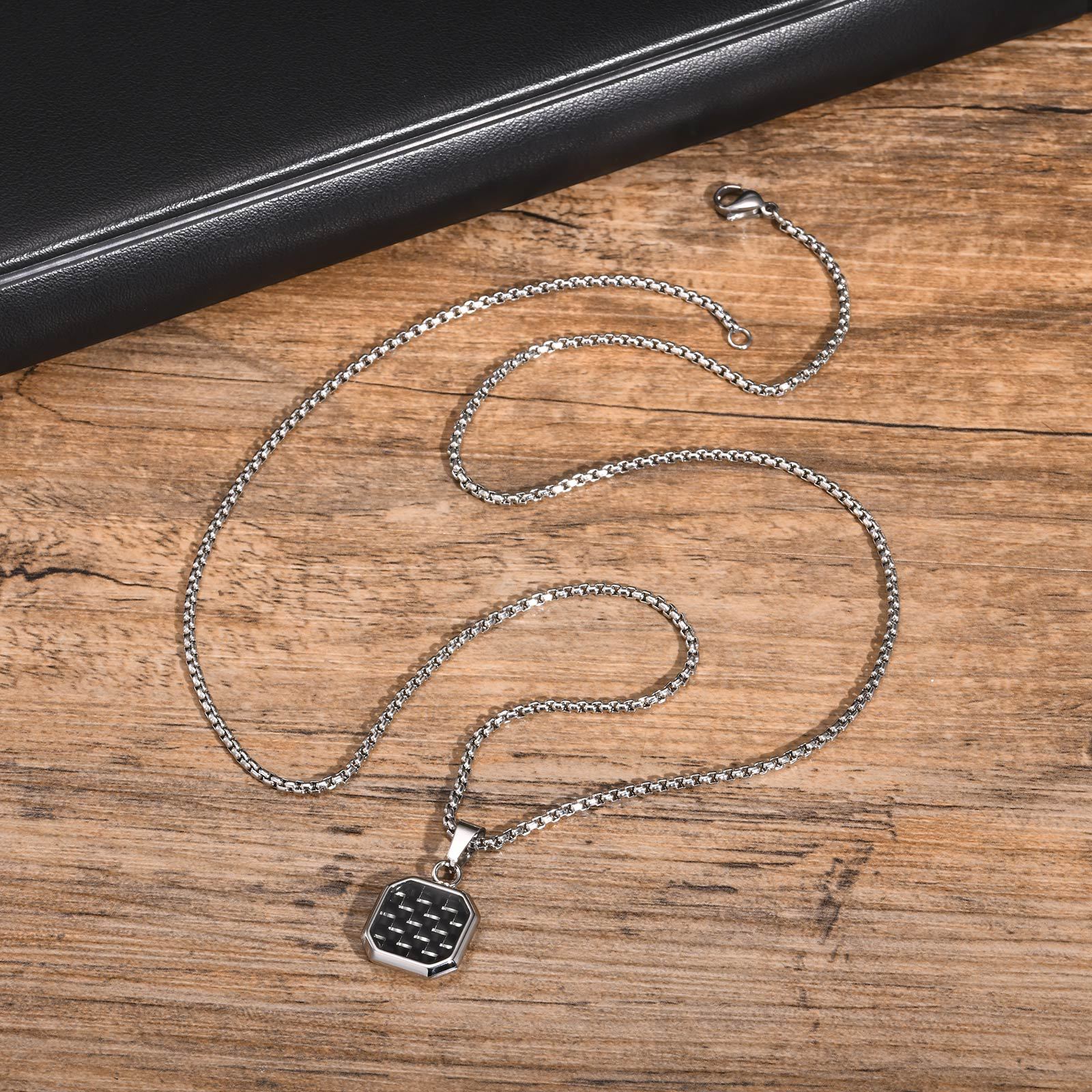 Silver chain necklace with a pendant on a wooden surface